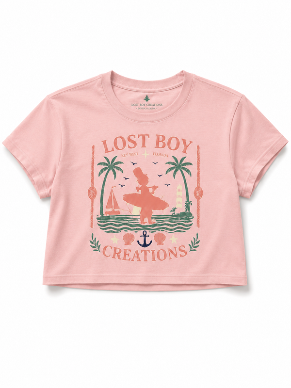 Women's Cropped Beach Day Tee in Dusty Blush — graphic front flat lay, Lost Boy Creations vintage Key West surfer scene with palm trees, sailboat, anchor, and seashells | Lost Boy Creations Key West
