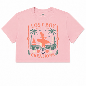 Women's Cropped Beach Day Tee in Dusty Blush — graphic front flat lay, Lost Boy Creations vintage Key West surfer scene with palm trees, sailboat, anchor, and seashells | Lost Boy Creations Key West