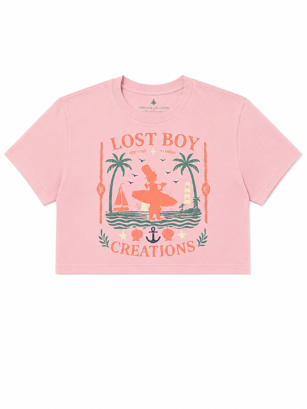 Women's Cropped Beach Day Tee in Dusty Blush — graphic front flat lay, Lost Boy Creations vintage Key West surfer scene with palm trees, sailboat, anchor, and seashells | Lost Boy Creations Key West