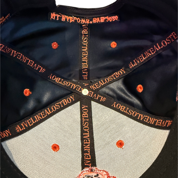 Lost Boy Creations Halloween Hat 2026 in Black — interior close-up, orange #LIVELIKEALOSTBOY seam tape and embroidered eyelets | Lost Boy Creations Key West