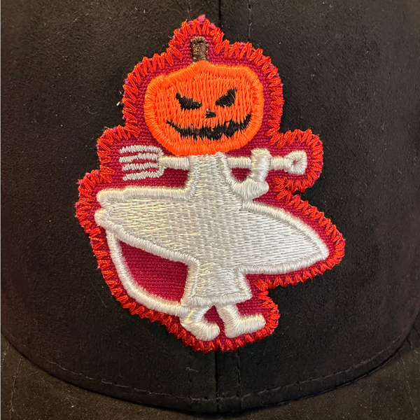 Lost Boy Creations Halloween Hat 2026 in Black — front logo close-up, orange jack-o'-lantern head, white Lost Boy figure and pitchfork | Lost Boy Creations Key West