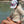 LBC Hooded Sun Shirt tan colorway — lifestyle shot of woman wearing sun shirt on a rock at the bridge | Lost Boy Creations Key West 
