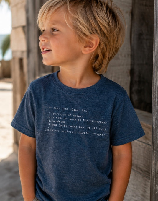 Kid's Lost Boy Definition Tee marine blue lifestyle shot worn by young boy showing Lost Boy definition graphic print | Lost Boy Creations Key West