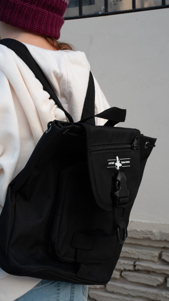 Mini Bag in Black — on-model lifestyle worn on back, white Lost Boy Creations silhouette logo | Lost Boy Creations Key West