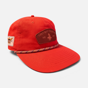 Tomato Soup Hat in Rustic Red — front three-quarter view, brown leather patch and decorative rope trim on the brim | Lost Boy Creations Key West