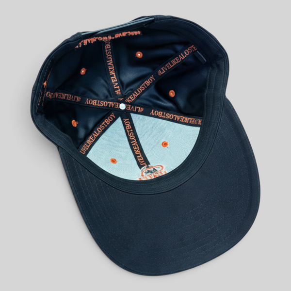 Lost Boy Creations Halloween Hat 2026 in Black — angled interior view, branded orange seam tape, orange eyelets and black sweatband | Lost Boy Creations Key West