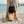 Mini Bag black water-resistant mini bag lifestyle shot held on sandy beach next to surfboard | Lost Boy Creations Key West