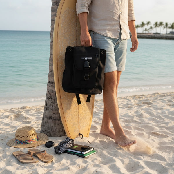 Mini Bag black water-resistant mini bag lifestyle shot held on sandy beach next to surfboard | Lost Boy Creations Key West