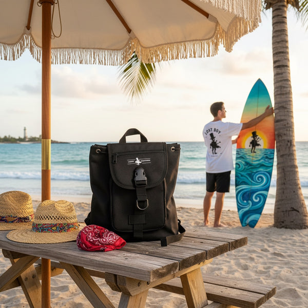 Mini Bag black water-resistant mini bag lifestyle shot on beach picnic table with surfer in background | Lost Boy Creations Key West