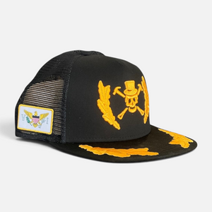 A Pirate's Life for Me Hat in Black — 3/4 angle, yellow pirate skull & crossbones emblem on front, gold laurel brim embroidery, USVI flag patch on side | Lost Boy Creations Key West