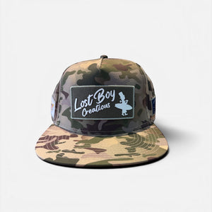 Big Wave Hunter Hat in Camouflage — three-quarter view, vintage LBC logo patch with USVI and Conch Republic flag patches | Lost Boy Creations Key West