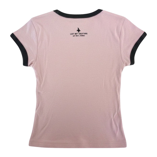Back view of Lost Boy Creations desert pink ringer tee with black contrast neck and sleeve bands and logo detail.
