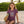 Kid's Tahiti Tee dragonfruit lifestyle shot worn by girl on beach holding surfboard with Lost Girl Creations surf graphic | Lost Boy Creations Key West