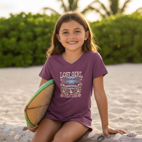 Kid's Tahiti Tee dragonfruit lifestyle shot worn by girl on beach holding surfboard with Lost Girl Creations surf graphic | Lost Boy Creations Key West