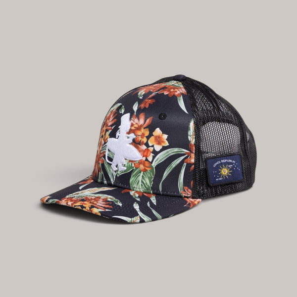 Lost Boy Creations Tarzan snapback hat featuring a floral front panel, black mesh back, and side flag patches.