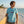 Man wearing Men's Hammerhead Tee light blue t-shirt with surfboard on sunny beach | Lost Boy Creations Key West