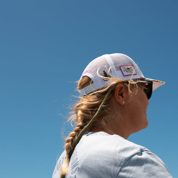 Lost Boy Creations Hokulea snapback hat with Hawaiian floral print and white mesh back worn by a woman against a bright blue sky | Lost Boy Creations Key West