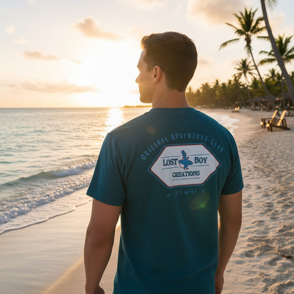 Men's Original Adventure Gear Tee in Marine Blue — lifestyle, man wearing tee with Original Adventure Gear back graphic at sunset | Lost Boy Creations Key West