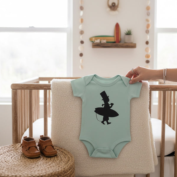 Kid's Lost Boy in Training Onesie in Fern — lifestyle shot, black LBC surfer silhouette graphic on mint green baby bodysuit, nursery setting | Lost Boy Creations Key West