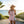 Women's Surfing Club Ringer Tee Desert Pink ringer tee held by model on tropical waterfront dock at sunset | Lost Boy Creations Key West