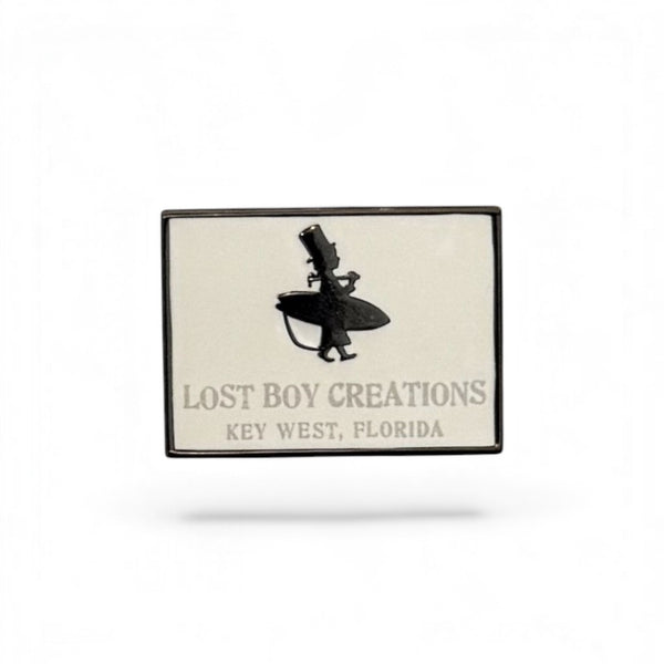 LBC Collectible Pin white and black enamel pin with Lost Boy surfer silhouette and Lost Boy Creations Key West Florida text | Lost Boy Creations Key West