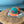 Lost Boy Creations Coral Reefer snapback hat with teal front, orange brim, and orange mesh back on a wooden table.