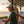 Forest Sand Dunes tan structured trucker hat lifestyle view worn by man on oceanfront deck at sunset with surfboard and palm trees Key West | Lost Boy Creations Key West